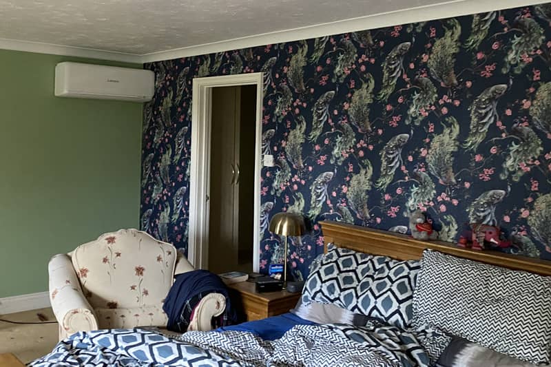 White wall mounted Mitsubishi air conditioner installed in a bedroom.