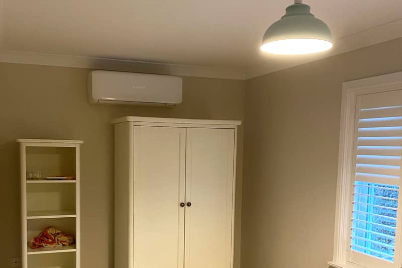 Wall mounted air conditioner installed in a guest bedroom.