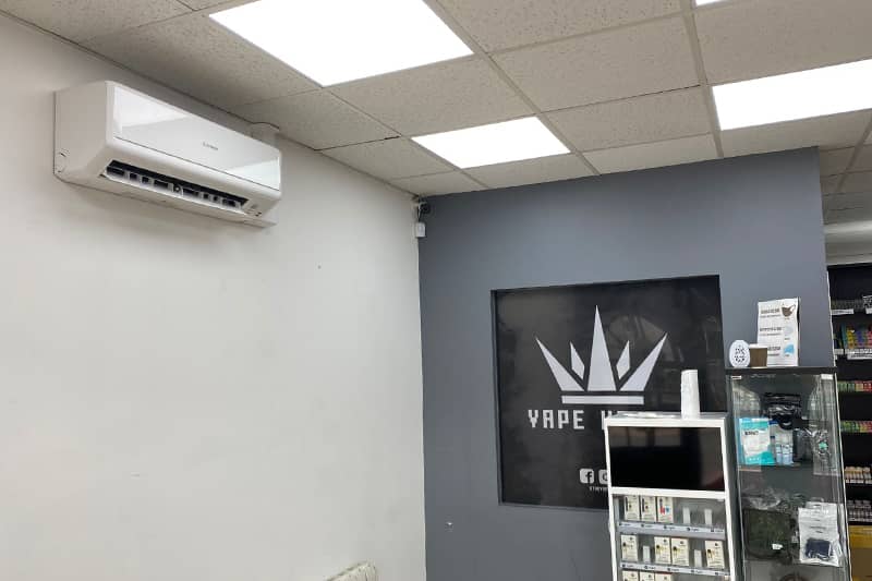 Wall mounted air conditioner installed on the wall of a vape store.