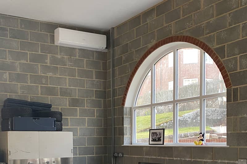 Wall mounted Mitsubishi air conditioner installed in a workshop.