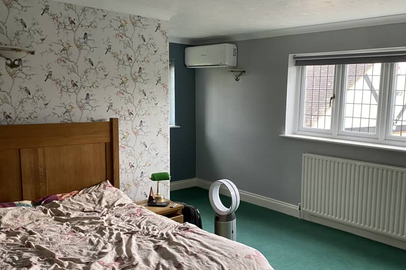 White wall mounted Mitsubishi air conditioner installed in a bedroom.