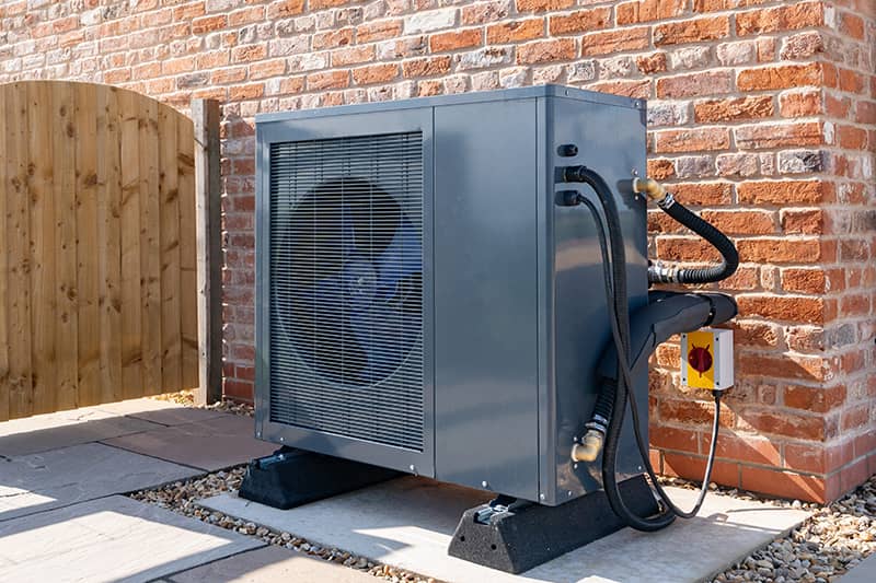 New air source heat pump fitted outside a new home.