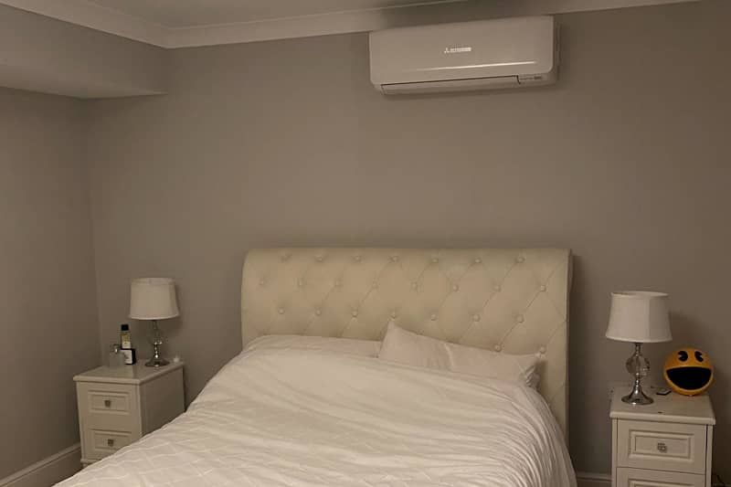 White air conditioning unit installed in a bedroom.