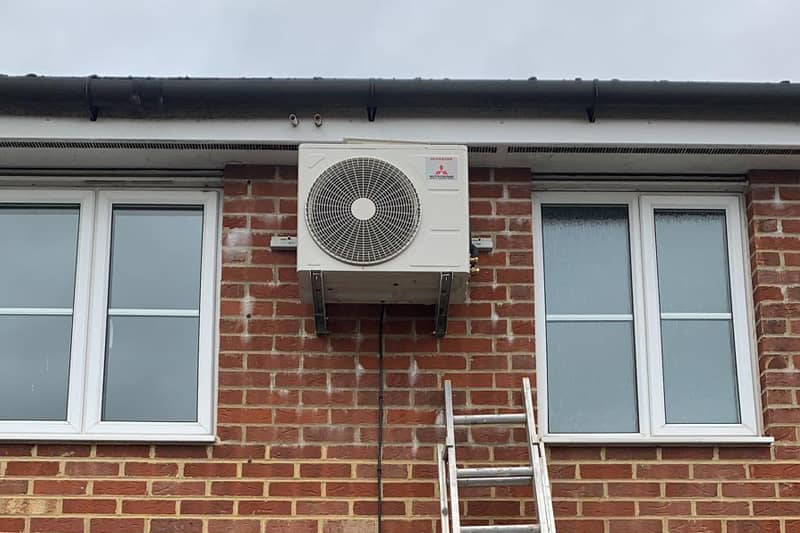 External Mitsubishi Inverter being installed at a home.