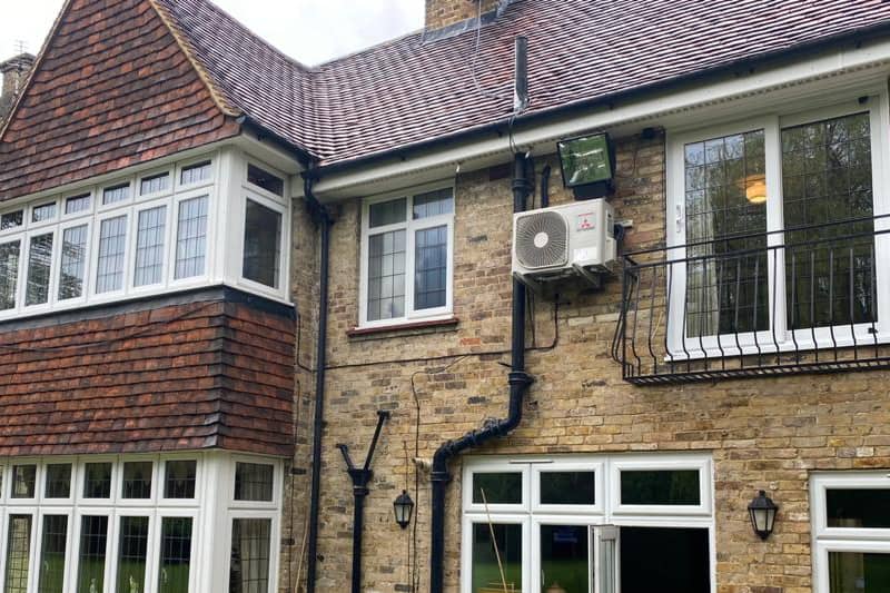 External Mitsubishi air conditioning inverter installed outside a home.