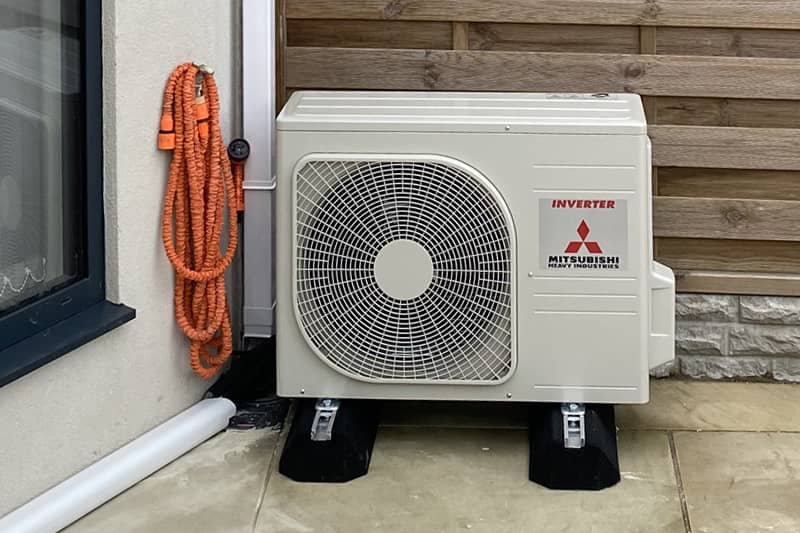 External Mitsubishi inverter installed to the rear of a domestic property.
