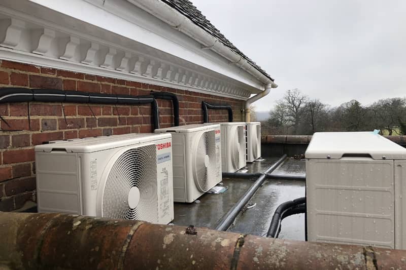 External Toshiba air conditioning units installed on a home flat roof.
