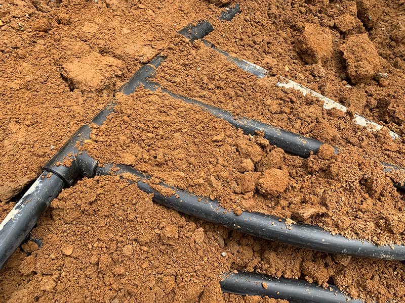 Geothermal ground source heat pump loop partially buried.