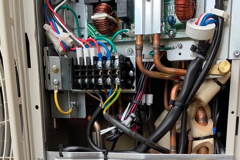 External Mitsubishi air conditioning inverter open for maintenance.