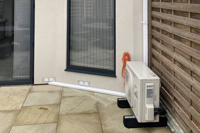 External Mitsubishi Inverter neatly installed in a home garden.