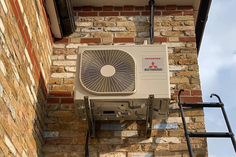 External Mitsubishi air conditioning inverter undergoing repair.