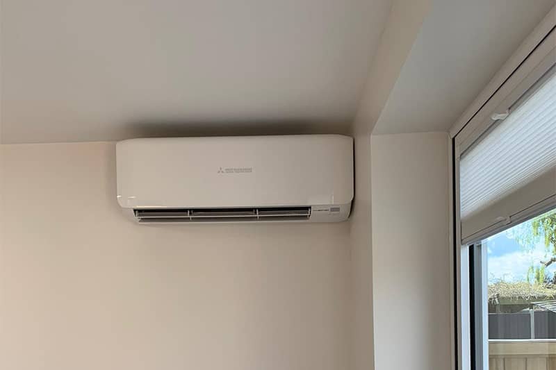 White wall mounted Mitsubishi air conditioner installed in a home.