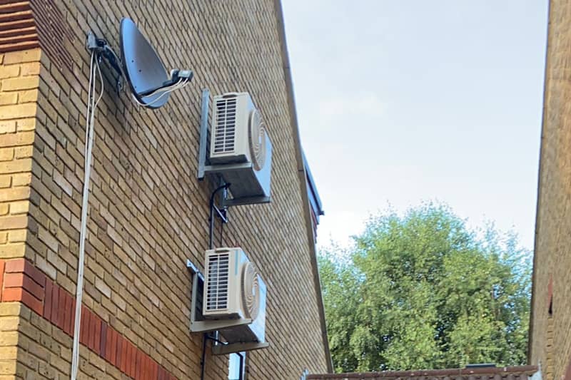 Two external air conditioning inverters mounted on a wall.