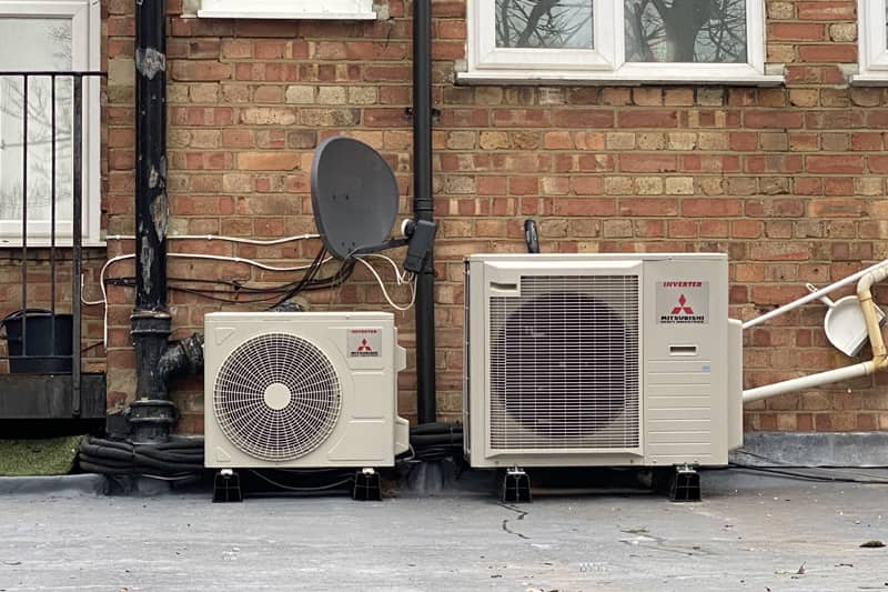 Two external Mitsubishi inverters installed on a flat roof.