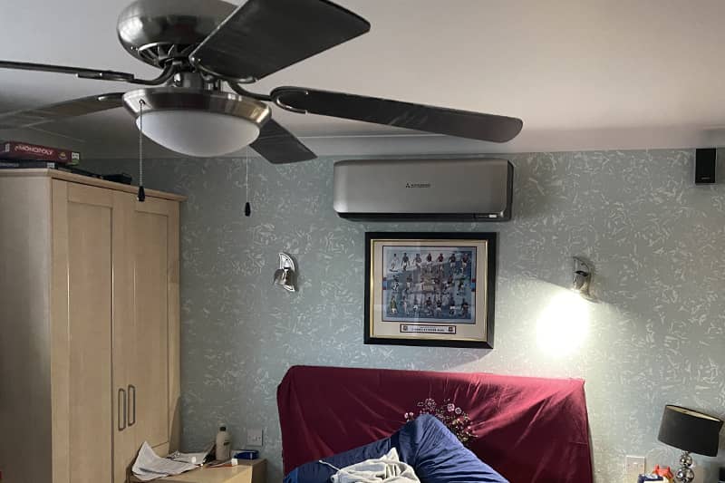 Wall mounted Mitsubishi air conditioner in a bedroom.