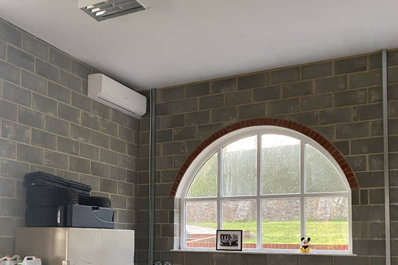 Wall mounted Mitsubishi air conditioner installed in a home workshop.